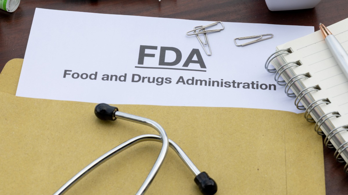 FDA regulatory documents beside a stethoscope and spiral notebook on a desk